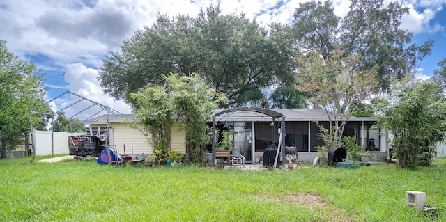 back of house with a yard and a sunroom