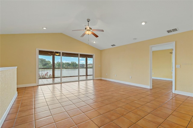 spare room with lofted ceiling, a water view, light tile patterned floors, and ceiling fan