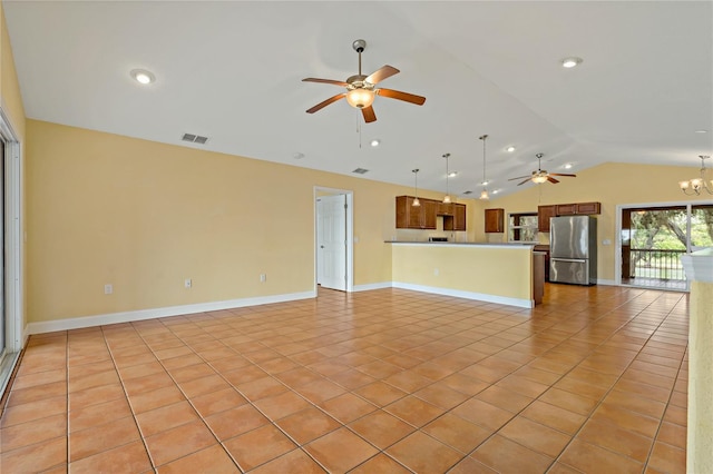 unfurnished living room featuring ceiling fan with notable chandelier, light tile patterned floors, and vaulted ceiling