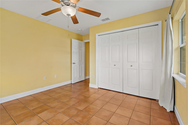 unfurnished bedroom featuring light tile patterned floors, ceiling fan, and a closet