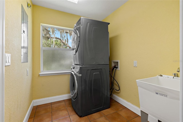 laundry room featuring stacked washer / drying machine, sink, and tile patterned floors