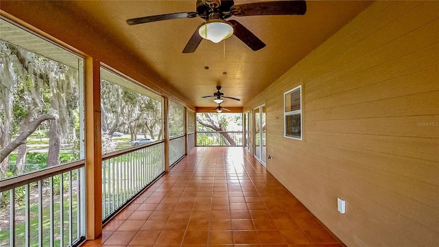 unfurnished sunroom featuring ceiling fan