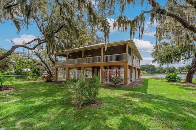 rear view of property with a water view and a yard