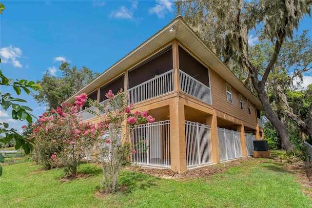 view of side of property with a yard and central AC