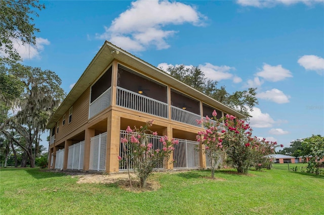 back of house featuring a balcony and a lawn