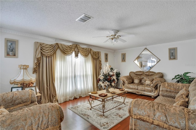 living room featuring a textured ceiling, ceiling fan, ornamental molding, and hardwood / wood-style floors