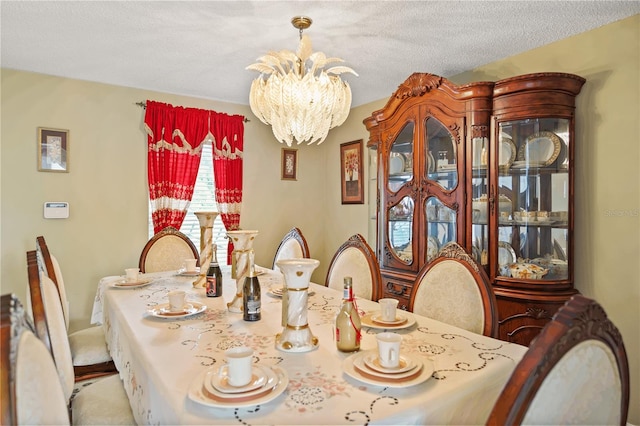 dining space with a textured ceiling and an inviting chandelier