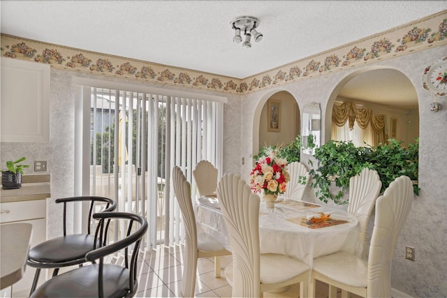 dining area with light tile patterned floors and a textured ceiling