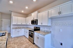 kitchen with stainless steel appliances, light stone countertops, and white cabinets