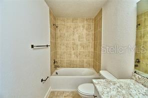 full bathroom featuring vanity, toilet, and tiled shower / bath