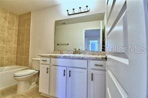 full bathroom featuring tiled shower / bath, vanity, toilet, and tile patterned flooring