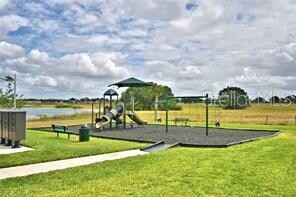 view of playground with a yard and a water view