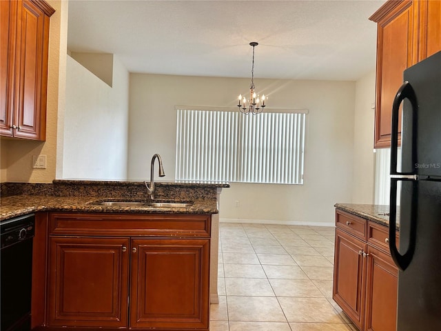 kitchen with dark stone countertops, light tile patterned floors, a chandelier, sink, and black appliances