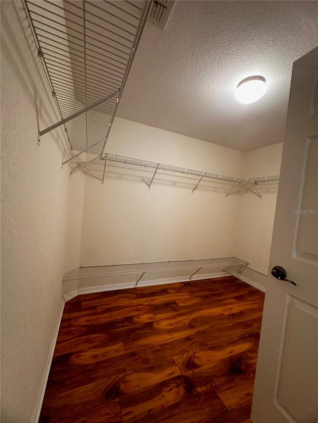 walk in closet with hardwood / wood-style floors