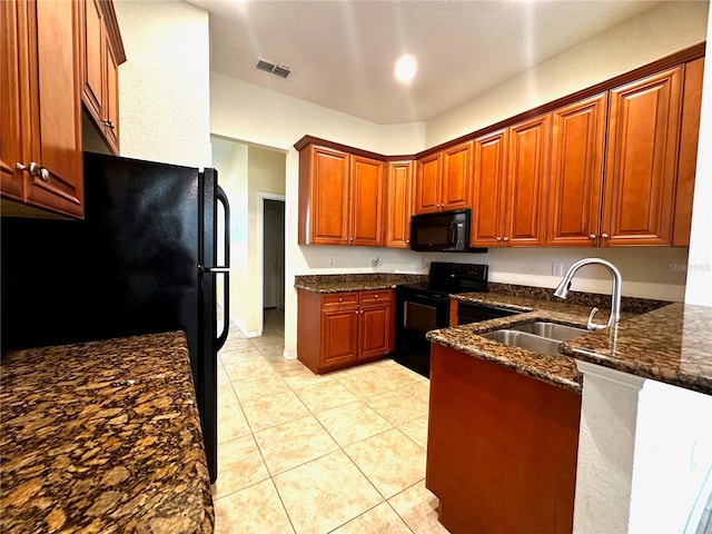 kitchen with black appliances, light tile patterned floors, sink, and dark stone counters