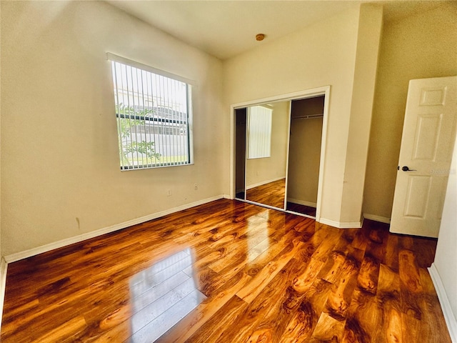 unfurnished bedroom with a closet and dark hardwood / wood-style floors