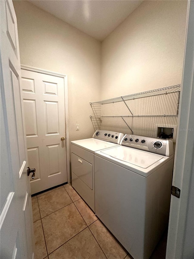 clothes washing area featuring independent washer and dryer and light tile patterned flooring