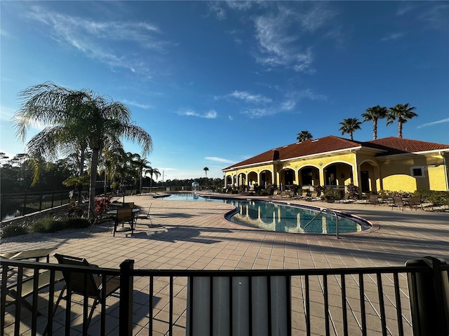 view of pool with a patio area and a water view