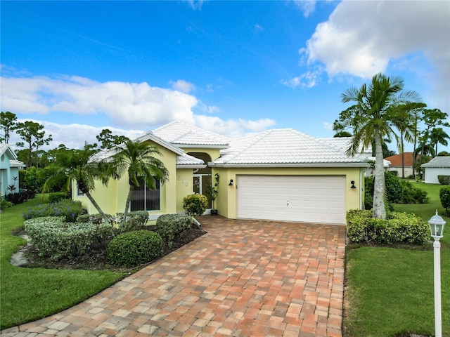 mediterranean / spanish house featuring a front lawn and a garage