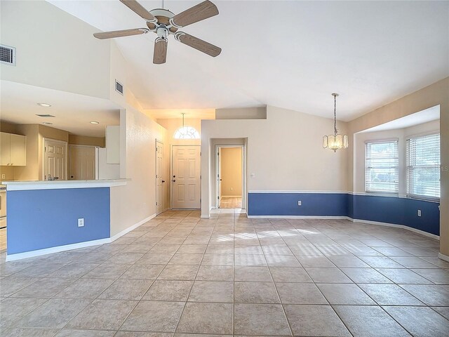 unfurnished living room featuring ceiling fan with notable chandelier, lofted ceiling, and light tile patterned floors