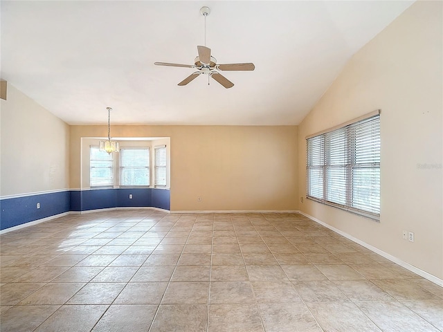 empty room with ceiling fan with notable chandelier, lofted ceiling, and light tile patterned floors