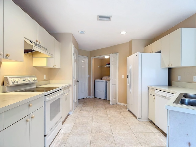 kitchen featuring washer and clothes dryer, white appliances, white cabinetry, and light tile patterned floors