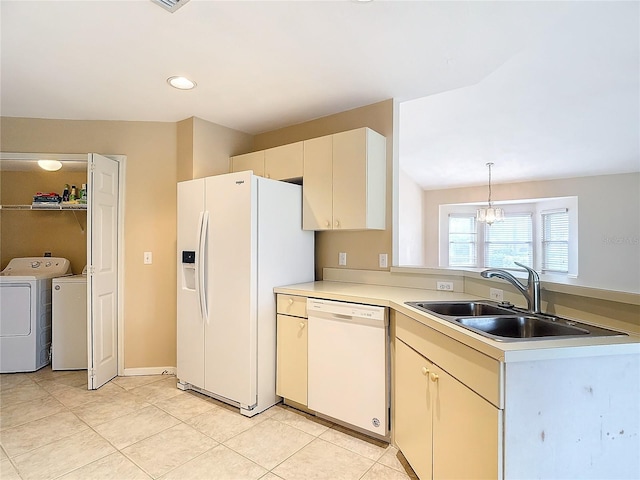 kitchen featuring light tile patterned flooring, sink, white appliances, decorative light fixtures, and washing machine and dryer