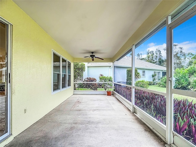 unfurnished sunroom with ceiling fan