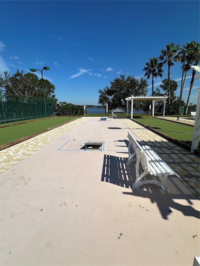 view of property's community with fence and a pergola