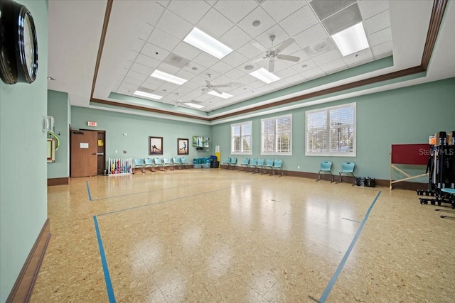 interior space featuring a paneled ceiling, a raised ceiling, and baseboards