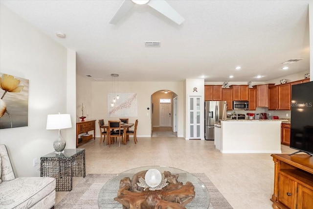 living room with a ceiling fan, arched walkways, visible vents, and recessed lighting