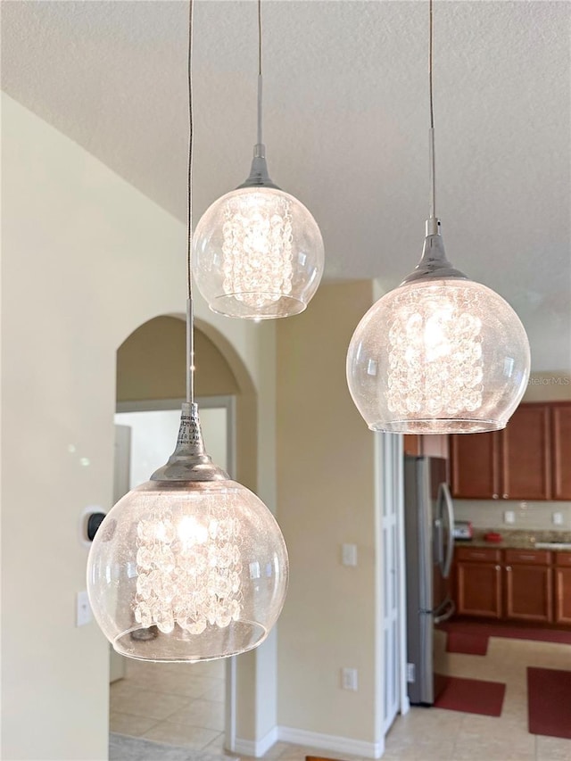 details with freestanding refrigerator, a notable chandelier, a textured ceiling, and baseboards