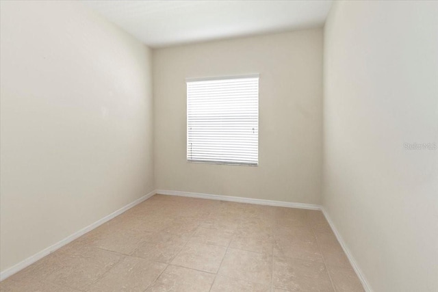 unfurnished room with baseboards