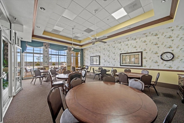 dining area featuring wallpapered walls, a ceiling fan, a raised ceiling, and carpet flooring