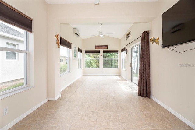 corridor with a wall unit AC, baseboards, vaulted ceiling, and a wealth of natural light