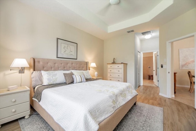 bedroom featuring visible vents, light wood-style flooring, and baseboards