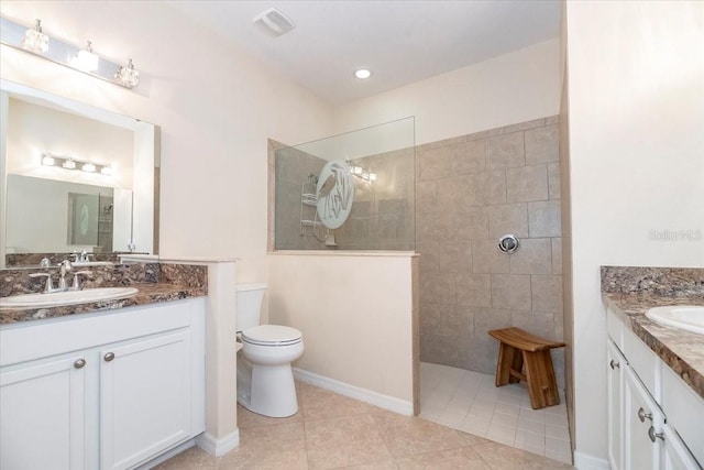 bathroom featuring two vanities, a sink, visible vents, and walk in shower