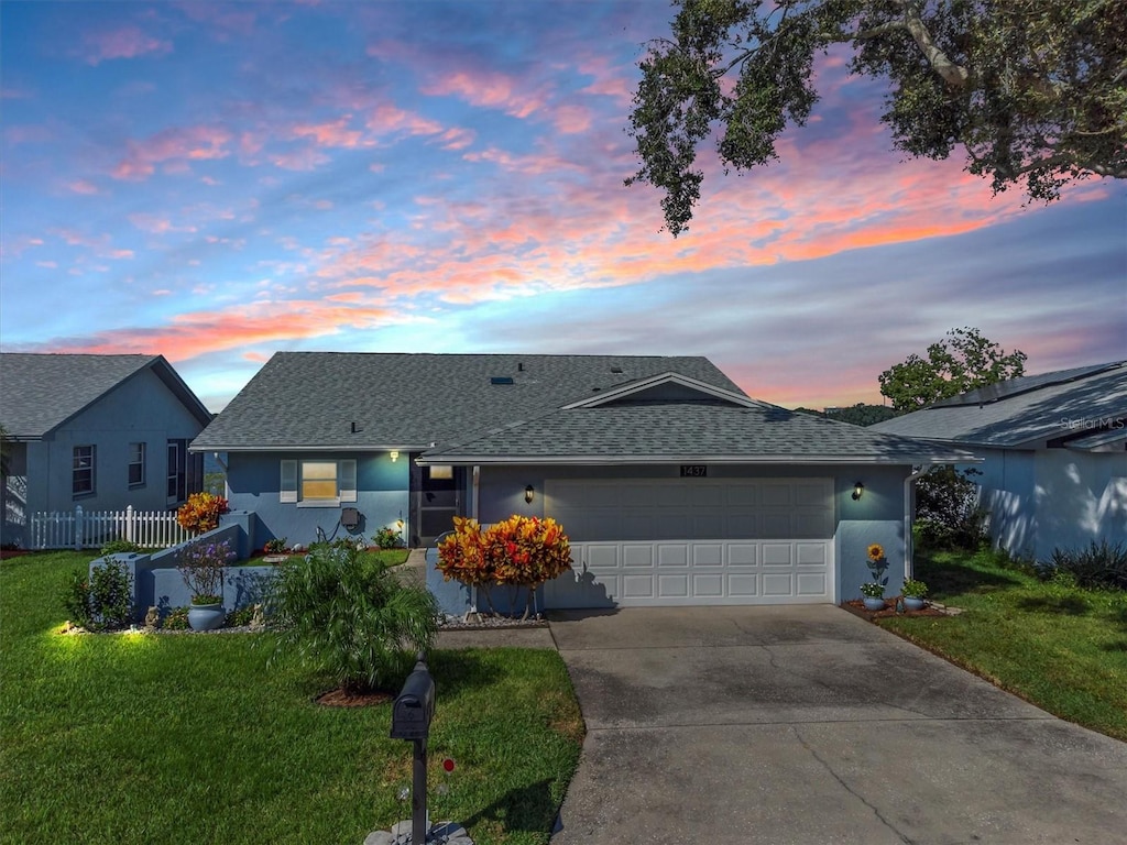 ranch-style home featuring a yard and a garage