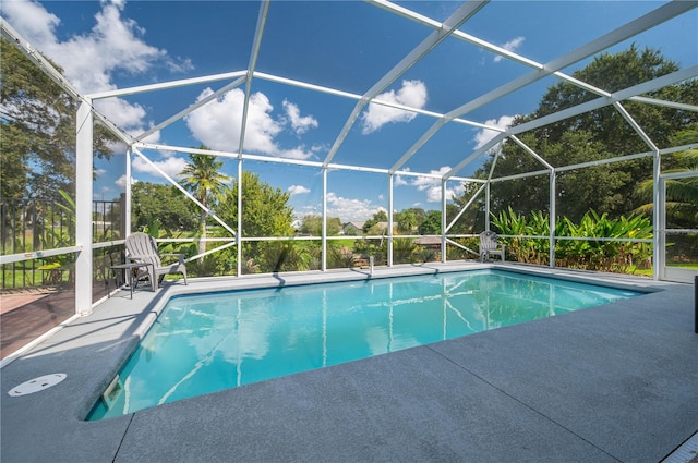 view of pool featuring glass enclosure and a patio