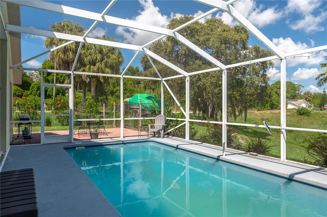 view of swimming pool with a lanai and a patio area