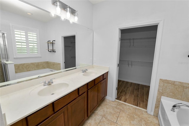 bathroom with vanity, tile patterned floors, and a tub to relax in