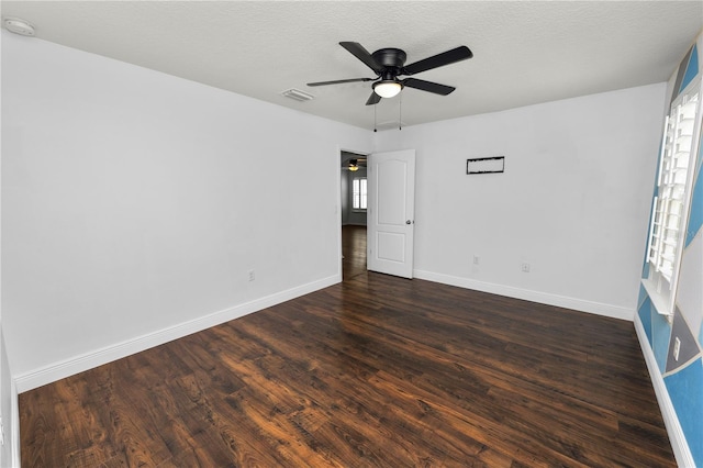 spare room with dark wood-type flooring, a textured ceiling, and ceiling fan