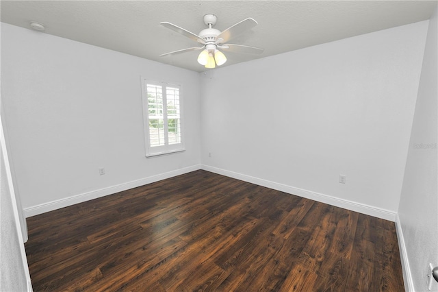 spare room with dark hardwood / wood-style flooring and ceiling fan