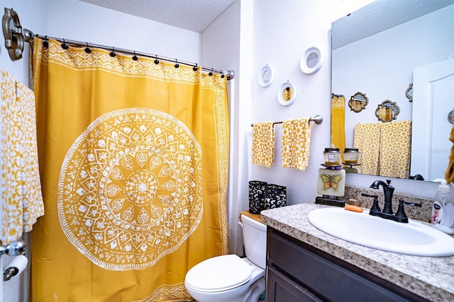 bathroom with a textured ceiling, vanity, and toilet