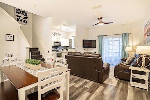 living room featuring wood-type flooring and ceiling fan