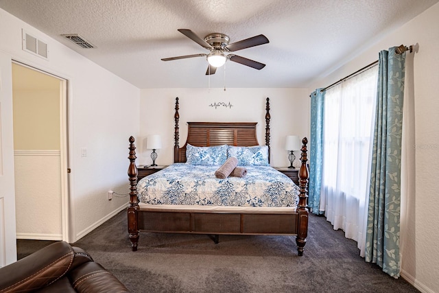 bedroom featuring ceiling fan, a textured ceiling, and dark colored carpet