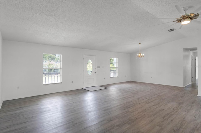 unfurnished living room with lofted ceiling, dark hardwood / wood-style floors, ceiling fan with notable chandelier, and a textured ceiling