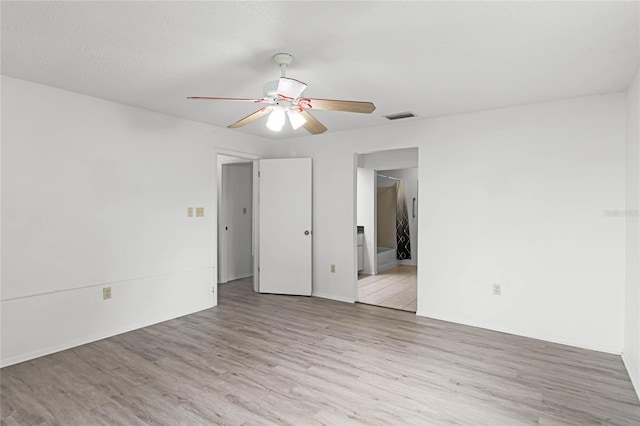 unfurnished room featuring a textured ceiling, ceiling fan, and light hardwood / wood-style flooring