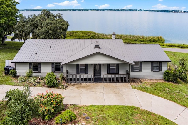 ranch-style house with a porch, a water view, and a front yard