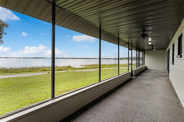 unfurnished sunroom with a water view, ceiling fan, and a healthy amount of sunlight